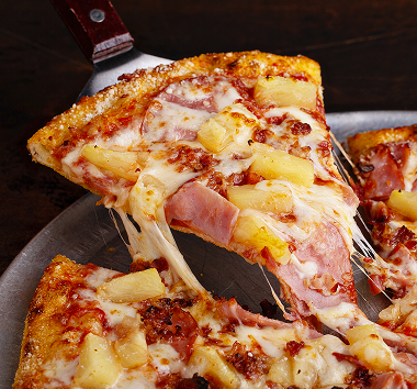 A pineapple pizza with pinapples, tomato sauce and cheese.