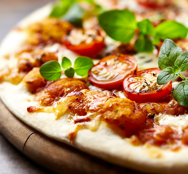 A Margherita pizza closeup with fresh tomatoes.
